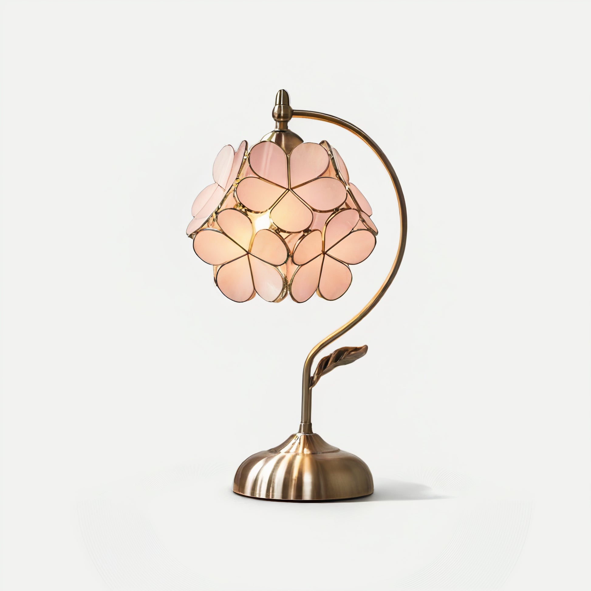 French vintage table lamp with pink floral shade and brass base on a white background